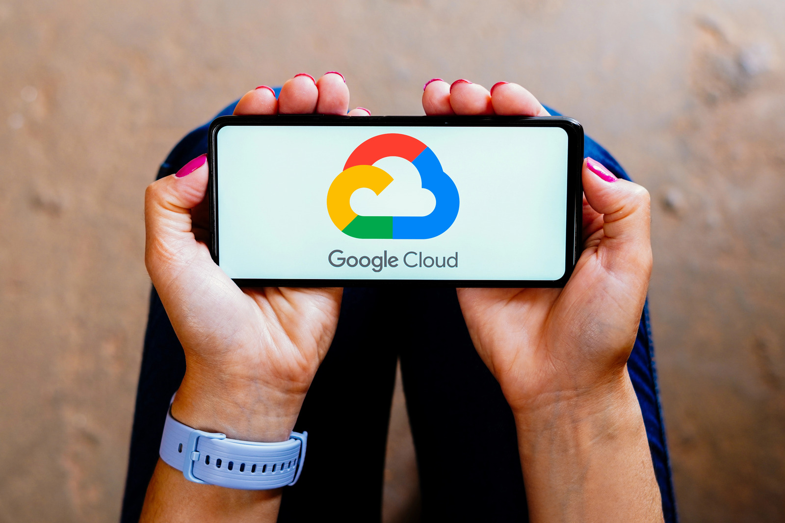 Hands holding a smartphone displaying the Google Cloud logo on the screen, highlighting Googles advancements in cloud AI technology.